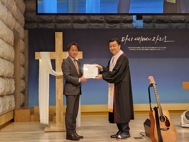 사진. (왼쪽부터) 본부 박영수 목사가 수동교회 정기수 담임목사에게 생명나눔예배 기념패를 전달하고 있다..jpg