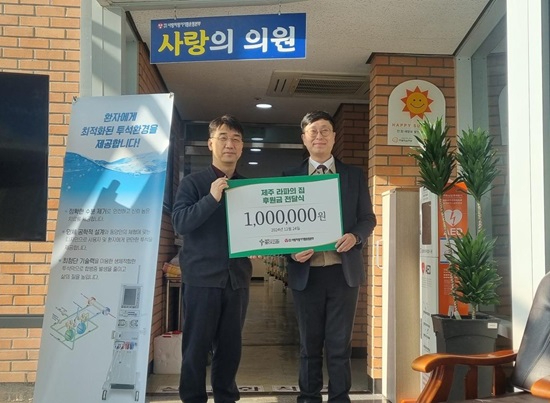 사진_로아교회 최기완 담임목사(오른쪽)가 본부 김동엽 상임이사에게 후원금을 전달하고 있다.jpg